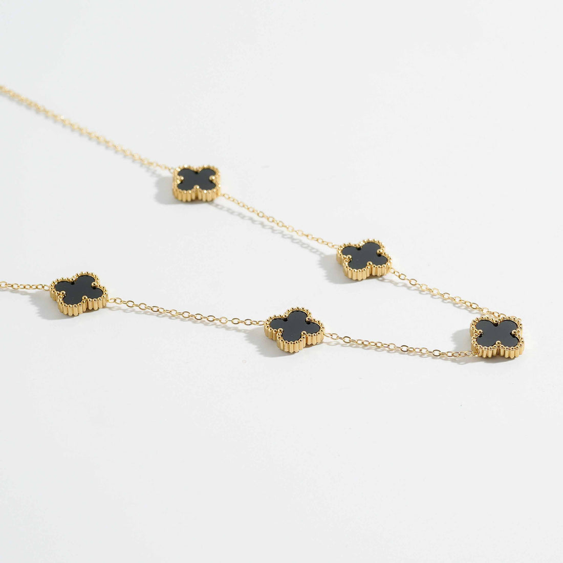 Trendy gold-tone chain necklace for women with black clover motifs. Elegant fashion necklace for everyday wear and special occasions.