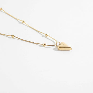 Elegant heart and beads pendant necklace with gold-tone chain. Stylish pendant for women with a modern heart charm, perfect for everyday wear.
