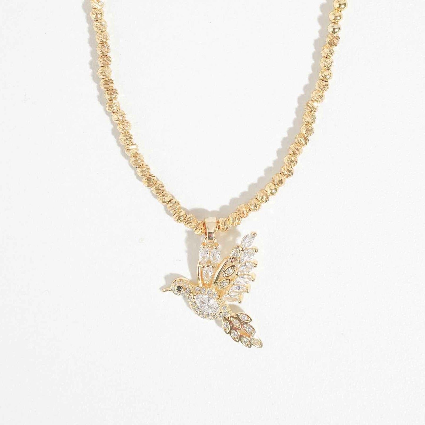 Trendy gold-tone pendant necklace with cubic zirconia and bird motif for women, perfect for special occasions and weddings.