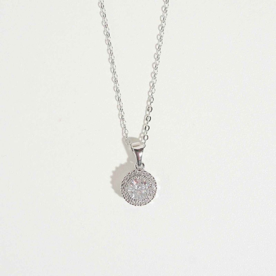 White Queen Necklace by Magnus, women’s pendant necklace with round halo-style white stone look, silver-tone chain, zircon necklace style in Pakistan