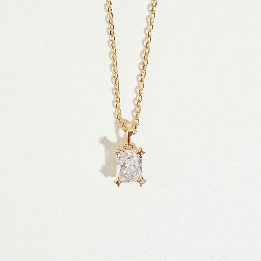 Emarald Gold Necklace by Magnus, women’s pendant necklace with rectangular clear stone look, gold-tone chain, zircon necklace style in Pakistan